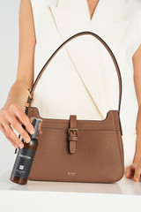 Profile view of model wearing the Oroton Dylan Baguette in Tan and Pebble Leather for Women .
