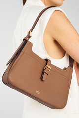 Profile view of model wearing the Oroton Dylan Baguette in Tan and Pebble Leather for Women .