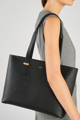 Profile view of model wearing the Oroton Anika 13" Tote & Cover in Black and Premium pebble leather for Women .