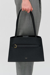 Profile view of model wearing the Oroton Audrey Small Three Pocket Day Bag in Black and Premiums saffiano and smooth leather for Women .