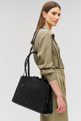 Profile view of model wearing the Oroton Audrey Three Pocket Day Bag in Black and Premium saffiano and smooth leather for Women .