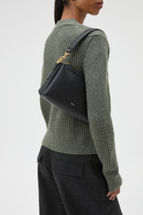 Profile view of model wearing the Oroton Alice Crossbody in Black and Premium pebbled leather exterior for Women .