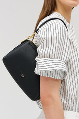 Profile view of model wearing the Oroton Alice Crossbody in Black and Premium pebbled leather exterior for Women .