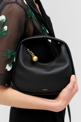 Profile view of model wearing the Oroton Clara Mini Bag in Black and Pebble leather for Women .