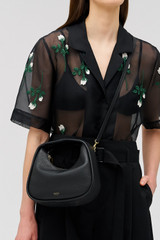 Profile view of model wearing the Oroton Clara Mini Bag in Black and Pebble leather for Women . IP:4