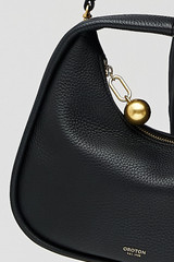Profile view of model wearing the Oroton Clara Mini Bag in Black and Pebble leather for Women .