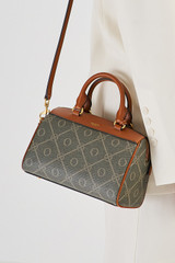 Profile view of model wearing the Oroton Harvey Signature Mini Barrel Bag in Black/Cognac and Nylon canvas base cloth material with PVC coating (70% PVC, 30% polyester) for Women .