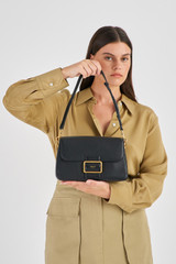 Profile view of model wearing the Oroton Astrid Shoulder Bag in Black and Pebble Leather for Women