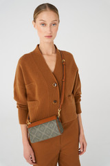 Profile view of model wearing the Oroton Harvey Signature Baguette Crossbody in Black/Cognac and Nylon canvas base cloth material with PVC coating (70% PVC, 30% polyester) for Women .