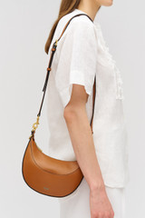 Profile view of model wearing the Oroton Florence Small Shoulder Bag in Cognac and Premium smooth leather for Women .