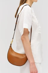 Profile view of model wearing the Oroton Florence Small Shoulder Bag in Cognac and Premium smooth leather for Women .