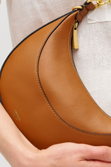Profile view of model wearing the Oroton Florence Small Shoulder Bag in Cognac and Premium smooth leather for Women .