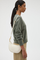 Profile view of model wearing the Oroton Florence Small Shoulder Bag in Clotted Cream and Premium smooth leather for Women .