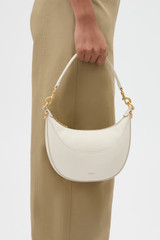 Profile view of model wearing the Oroton Florence Small Shoulder Bag in Clotted Cream and Premium smooth leather for Women .