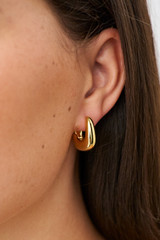 Profile view of model wearing the Oroton Raelyn Hoops in Gold and Brass for Women .