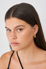 Profile view of model wearing the Oroton Raelyn Hoops in Gold and Brass for Women .
