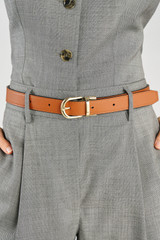 Profile view of model wearing the Oroton Inez Reversible Belt in Black/Cognac and Premium saffiano leather for Women .