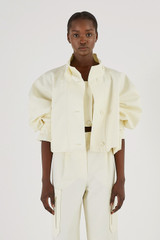 Profile view of model wearing the Oroton Crop Trench in Cream and 77% Cotton 23% Linen for Women