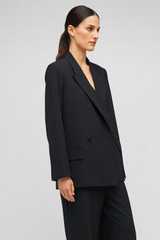 Profile view of model wearing the Oroton Double Breasted Blazer in Black and 53% polyester, 42% virgin wool, 5% elastane for Women