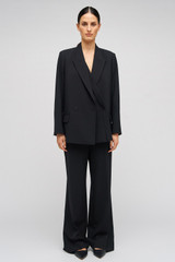 Profile view of model wearing the Oroton Double Breasted Blazer in Black and 53% polyester, 42% virgin wool, 5% elastane for Women