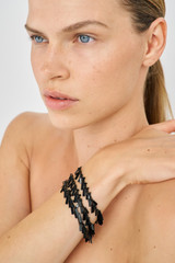 Profile view of model wearing the Oroton Vera Bracelet in Black and 100% Metal for Women .