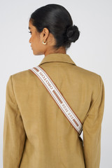 Profile view of model wearing the Oroton Heather Long Webbing Strap in Cognac/Natural and Polyester webbing strap and pebble leather trim for Women