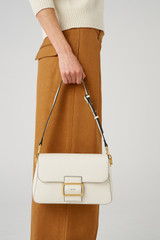 Profile view of model wearing the Oroton Astrid Shoulder Bag in Cream and Pebble leather for Women