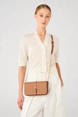 Profile view of model wearing the Oroton Dylan Clutch Crossbody in Tan and Pebble leather, smooth leather trims for Women