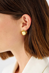 Profile view of model wearing the Oroton Josie Huggies in 18K Gold and Sustainably sourced 925 Sterling Silver for Women