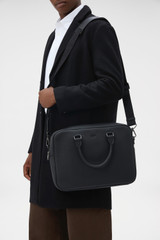 Profile view of model wearing the Oroton Porter Pebble 15" Griptop in Black and Premium pebble leather for Men .