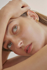 Profile view of model wearing the Oroton Addie Studs in 18K Gold and Sustainably sourced 925 Sterling Silver for Women