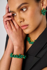 Profile view of model wearing the Oroton Jupiter Bracelet in Worn Gold/Malachite and Brass for Women