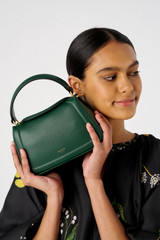 Profile view of model wearing the Oroton Reed Small Day Bag in Dark Treehouse and Pebble leather for Women