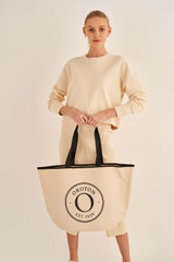 Profile view of model wearing the Oroton Kaia Shopper Tote in Natural/Black and Coated canvas material for Women .