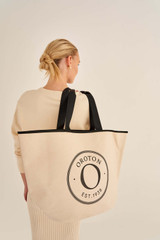 Profile view of model wearing the Oroton Kaia Shopper Tote in Natural/Black and Coated canvas material for Women .