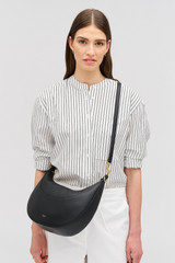 Profile view of model wearing the Oroton Florence Medium Hobo in Black and Smooth leather material for Women .