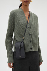 Profile view of model wearing the Oroton Margot Phone Crossbody in Black and Premium pebble leather for Women .