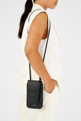 Profile view of model wearing the Oroton Margot Phone Crossbody in Black and Premium pebble leather for Women .