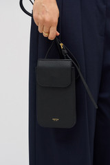 Profile view of model wearing the Oroton Margot Phone Crossbody in Black and Premium pebble leather for Women .