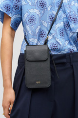 Profile view of model wearing the Oroton Margot Phone Crossbody in Black and Premium pebble leather for Women .