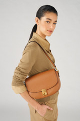 Profile view of model wearing the Oroton Yvonne Medium Day Bag in Tan and Pebble Leather for Women .