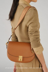 Profile view of model wearing the Oroton Yvonne Medium Day Bag in Tan and Pebble Leather for Women .