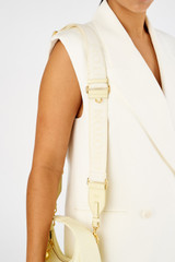 Profile view of model wearing the Oroton Fife Webbing Strap in Lemon Butter and Poly Jacquard webbing for Women .