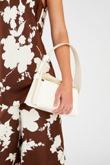 Profile view of model wearing the Oroton Caroline Small Day Bag in Paper White and Smooth leather for Women