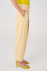 Profile view of model wearing the Oroton Twill Pleat Pant in Pink Sand and 77% cotton 23% linen for Women