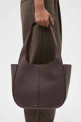 Profile view of model wearing the Oroton Emilia Tote in Bear Brown and Premium pebble leather for Women .