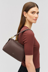 Profile view of model wearing the Oroton Alice Crossbody in Bear Brown and Premium pebbled leather exterior for Women .