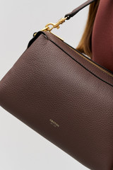 Profile view of model wearing the Oroton Alice Crossbody in Bear Brown and Premium pebbled leather exterior for Women .