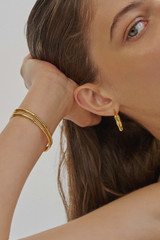 Profile view of model wearing the Oroton Fife Large Hoops in 18K Gold and Sustainably sourced 925 Sterling Silver for Women