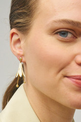 Profile view of model wearing the Oroton Lillium Drop Earrings in Gld/Clotted Crm and Brass for Women